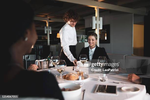 business people dining in a luxury restaurant - waiter stock pictures, royalty-free photos & images