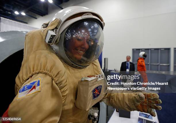 Monica Luna looks out of the helmet of a Sokol space suit during the Spacecom Space Commerce Conference and Exposition at George R. Brown Convention...