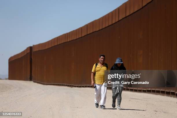 Immigrants walk along the border fence to turn themselves over to U.S Border Patrol agents along the U.S.-Mexico border on Thursday, May 11, 2023 in...