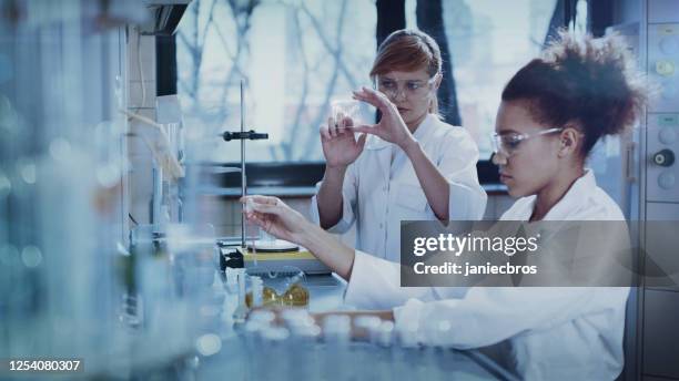 multi ethnic female team studying dna mutations. virtual touch screens - genetic screening stock pictures, royalty-free photos & images