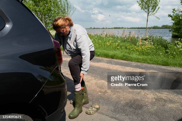 Heidi Looy of nature organisation Natuurlijkheidi puts boots on to collect dead birds on the islands of S' Gravenbroek lake on May 12, 2023 in Gouda,...