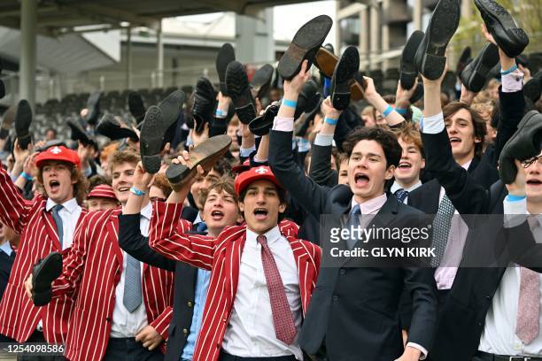Eton schoolboys cheer on their team from the grandstand during the Eton v Harrow cricket match at Lord's Cricket Ground in London on May 12, 2023....