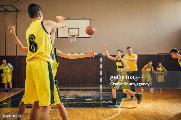 teenage boys basketball players on training indoors - passar a bola imagens e fotografias de stock