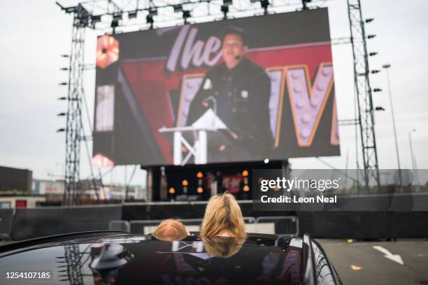 Audience members watch a slide presentation during a live comedy performance by Dom Joly at the Drive-In Club venue on July 03, 2020 in London,...