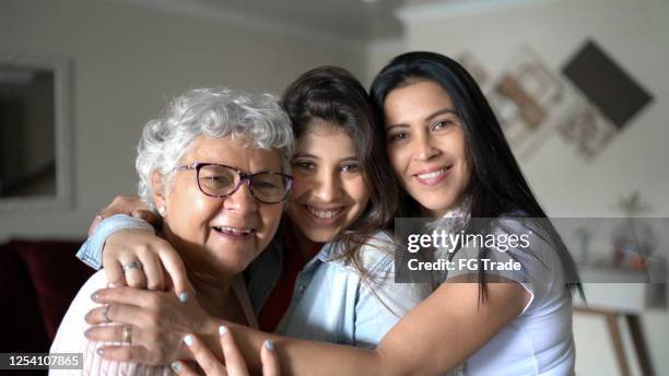 de familie van drie generatievrouwen thuis - reünie sociaal stockfoto's en -beelden