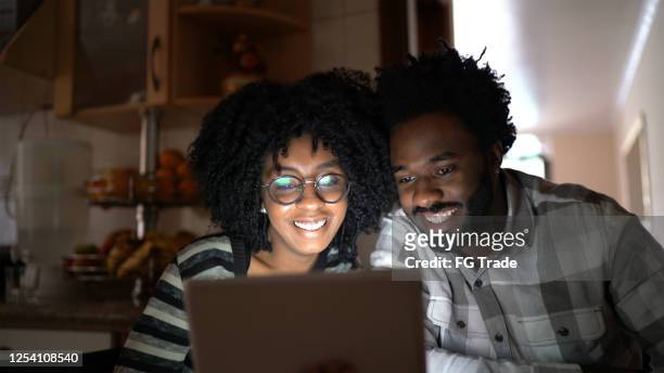 pareja viendo algo en la tableta digital en casa - lovers 2020 film fotografías e imágenes de stock