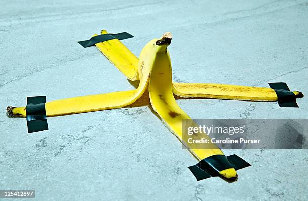 banana peel taped down to the floor - insurance stock-fotos und bilder
