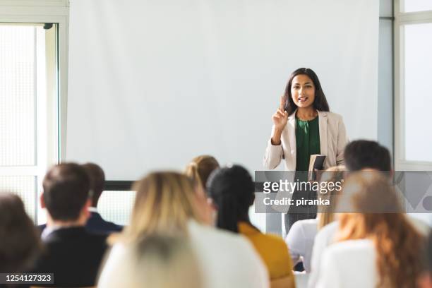 businesswoman holding a speech - corporate business stock pictures, royalty-free photos & images