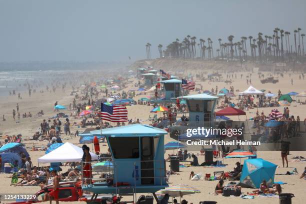 People gather at the beach on July 03, 2020 in Huntington Beach, California. Most of Orange County beaches and piers will be closed for the July 4th...