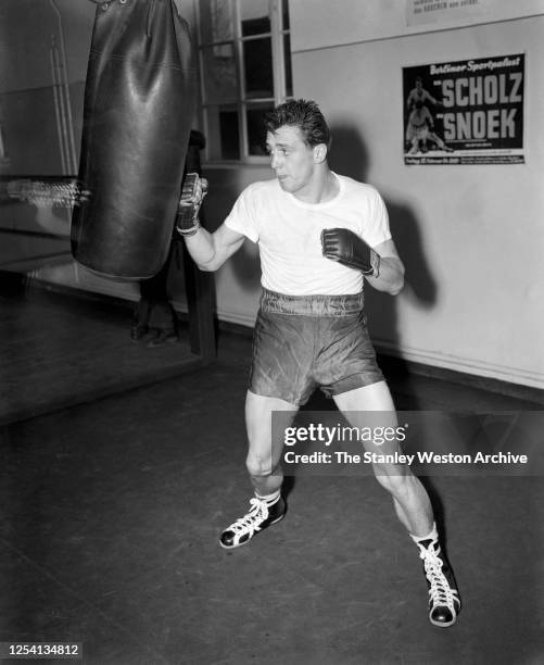 Middleweight professional boxer Gustav Bubi Scholz of Germany hits the punching bag while training circa 1954 at Stillman's Gym in New York, New York.