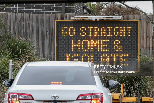 Sign reading 'Go straight home and Isolate' is seen at the exit of a drive through covid-19 testing site at Highpoint shopping centre on July 04,...