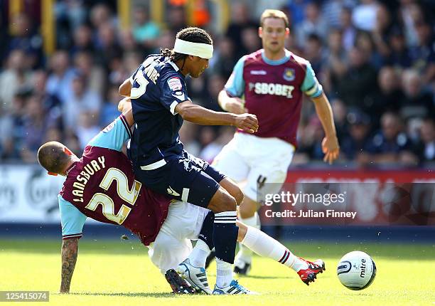 Tamika Mkandawire of Millwall is tackled by Henri Lansbury of West Ham United during the npower Championship match between Millwall and West Ham...