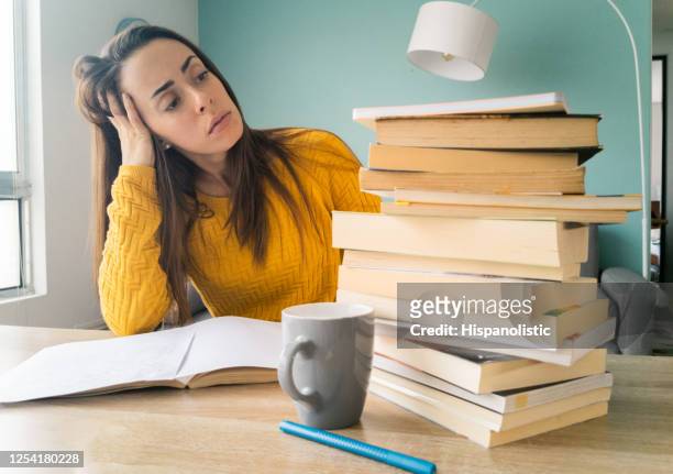 frustrated student looking at all the books she has to read while homeschooling - overworked teacher stock pictures, royalty-free photos & images