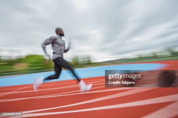 young african american man running at tartan. - sprint track stock pictures, royalty-free photos & images