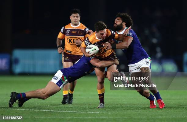 Brodie Croft of the Broncos is tackled by Adam Blair of the Warriors during the round eight NRL match between the New Zealand Warriors and the...