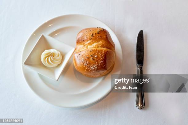 exquisite bread with butter curl on white plate - butter curl stock-fotos und bilder