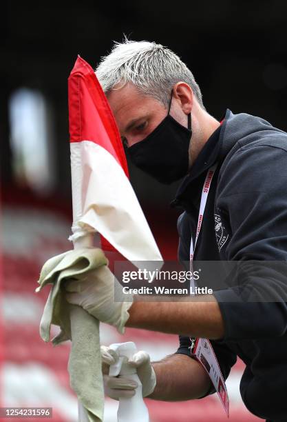 Member of the ground staff cleans the corner flag ahead of the Sky Bet Championship match between Brentford and Wigan Athletic at Griffin Park on...