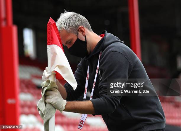 Member of the ground staff cleans the corner flag ahead of the Sky Bet Championship match between Brentford and Wigan Athletic at Griffin Park on...