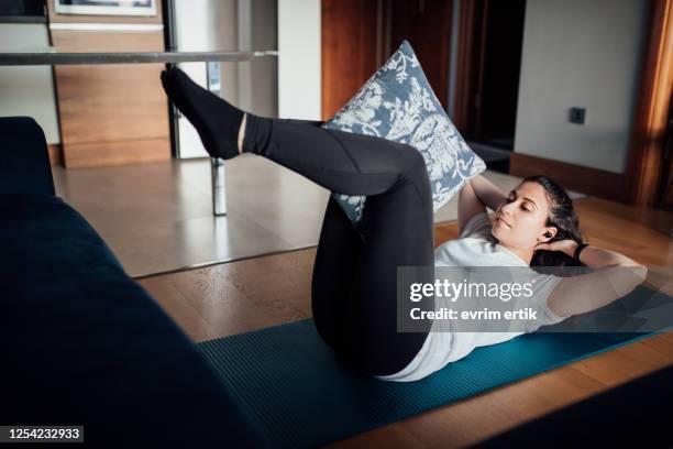 woman doing core exercise with pillow at home - core strength stock pictures, royalty-free photos & images
