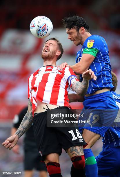 Pontus Jansson of Brentford FC heads the ball as he is challenged by Kieffer Moore of Wigan Athletic during the Sky Bet Championship match between...