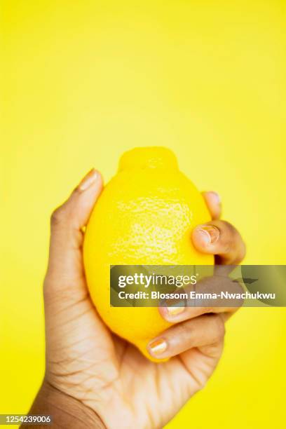 hand holding lemon - emma limon fotografías e imágenes de stock