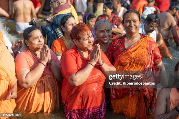 mulheres devota rezando no mergulho sagrado. - kumbh mela prayagraj - fotografias e filmes do acervo