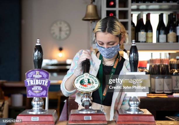 Employees pull pints at the Lordship pub in East Dulwich on July 04, 2020 in London, England. The UK Government announced that Pubs, Hotels and...