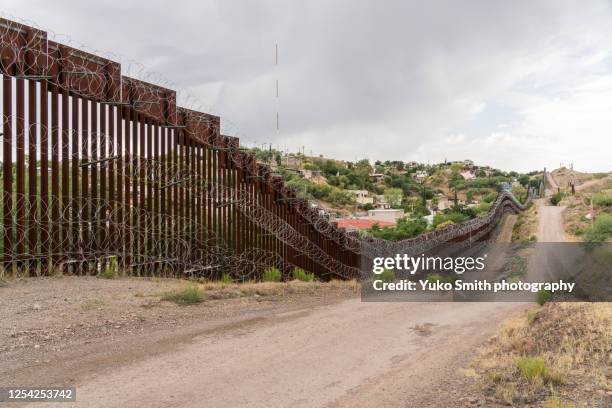 the us/mexico border fence in nogales, arizona usa - barreira transfronteiriça imagens e fotografias de stock