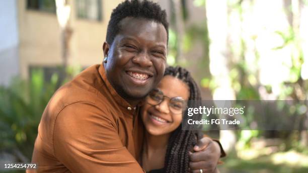 retrato de padre e hija abrazando fuera - braces fotografías e imágenes de stock