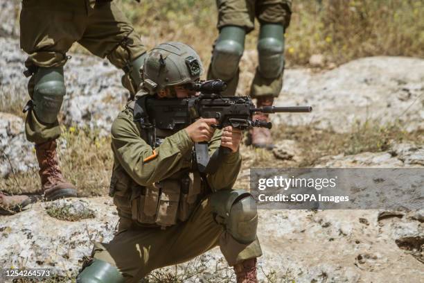 An Israeli soldier seen aiming towards Palestinian protesters during the demonstration against Israeli settlements in the village of Beit Dajan near...