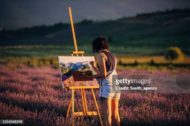 female painter painting on lavender field in sunset - artist easel stock pictures, royalty-free photos & images