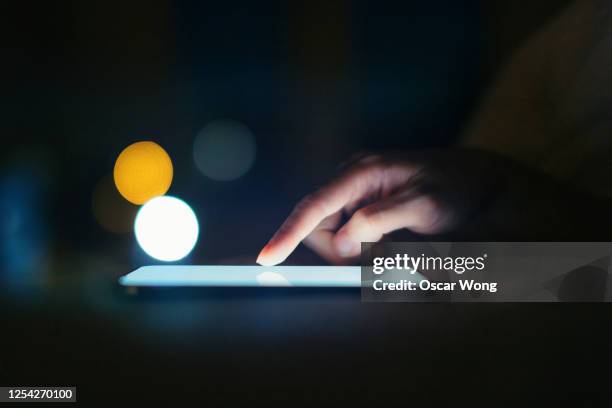 female hands using smart phone in the dark at night - business person on computer screen stock-fotos und bilder