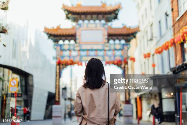 young woman walking on the streets at chinatown, london - chinatown stock pictures, royalty-free photos & images