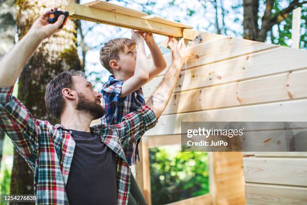 vater und sohn bauen baumhaus im hinterhof - tree house stock-fotos und bilder