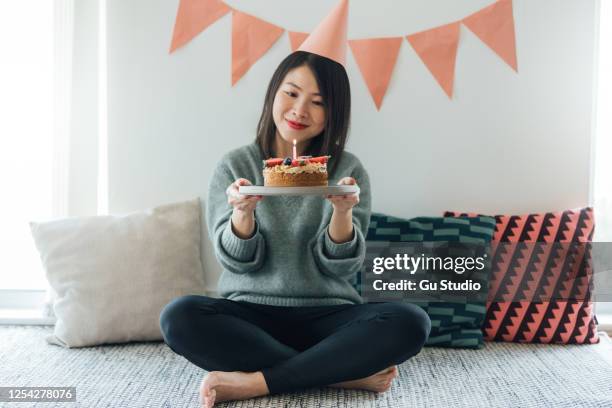 young woman celebrating birthday with a birthday cake - holding birthday cake stock pictures, royalty-free photos & images