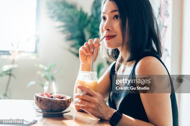 young woman eating heathy vegan breakfast in the morning - metal drinking straw stock pictures, royalty-free photos & images