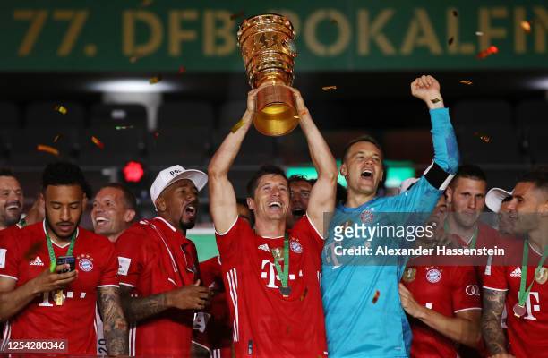 Robert Lewandowski of FC Bayern Muenchen lifts the trophy in celebration with his team mates after the DFB Cup final match between Bayer 04...