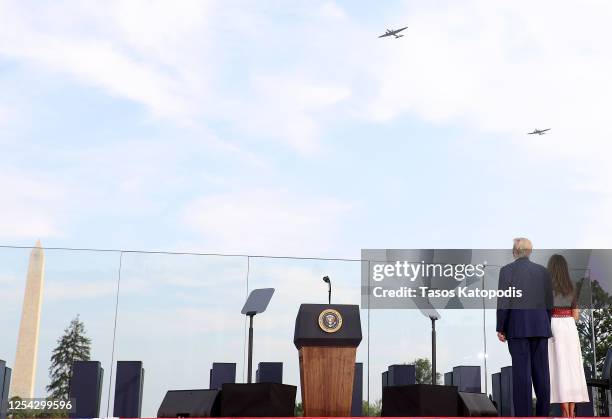 President Donald Trump and first lady Melania Trump watch as vintage WWII aircraft perform a flyover near the White House on July 04, 2020 in...