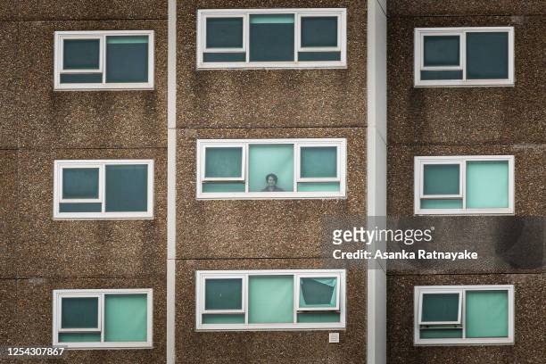 Lone woman is seen looking out the window of her apartment at the North Melbourne Public housing flats on July 05, 2020 in Melbourne, Australia. Nine...