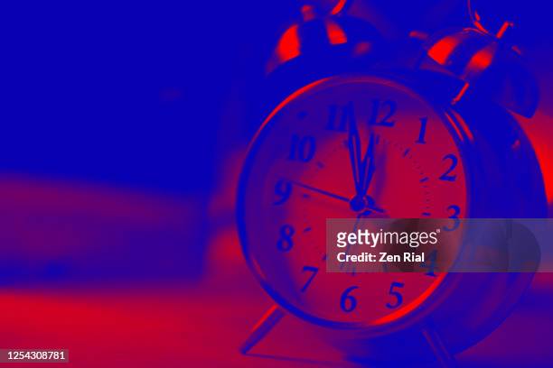analog alarm clock showing clock hands at close to 12:00 o'clock - digital countdown stock-fotos und bilder
