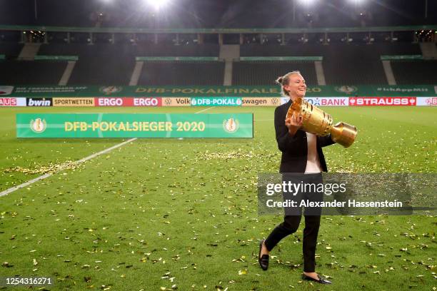 Team manager Kathleen Krueger of FC Bayern Muenchen poses with the trophy in celebration after the DFB Cup final match between Bayer 04 Leverkusen...