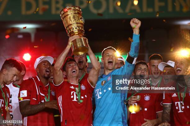 Robert Lewandowski of FC Bayern Muenchen lifts the DFB Cup winners trophy in celebration after the DFB Cup final match between Bayer 04 Leverkusen...