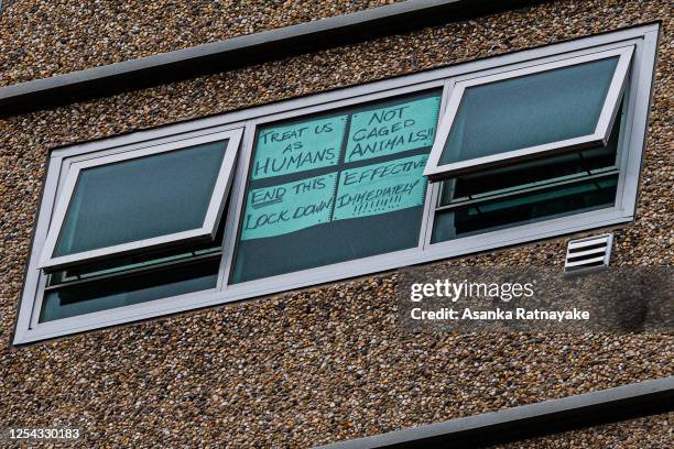 Sign is seen stuck to a window reading 'Treat us as humans not caged animals end this lockdown effective immediately' at the Flemington Public...