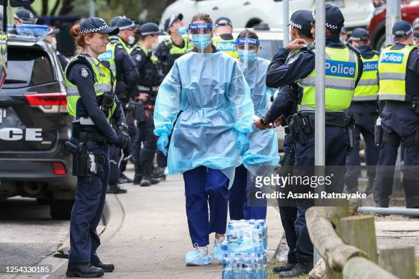 Medical staff wearing PPE holding material about to walk into the Flemington Public housing flats on July 05, 2020 in Melbourne, Australia. Nine...