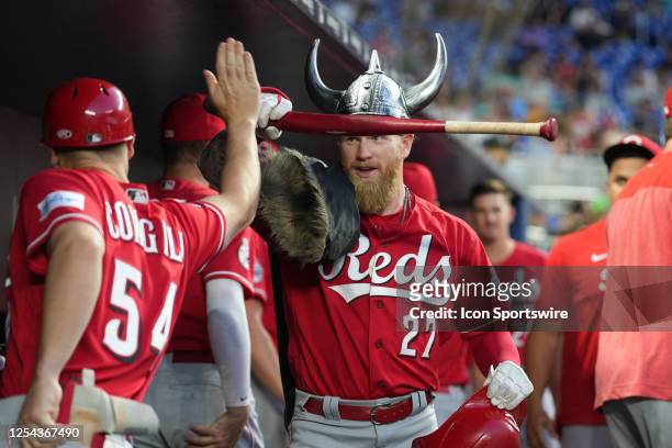 Cincinnati Reds right fielder Jake Fraley gets a high five while donning a viking hat and cape following his homer during the game between the...