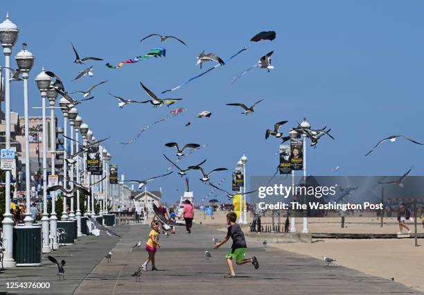 Bryleigh Koon left, and her brother Koulton both of Winchester, Va., chase seagulls on the boardwalk at the beginning of the Labor Day Weekend on...