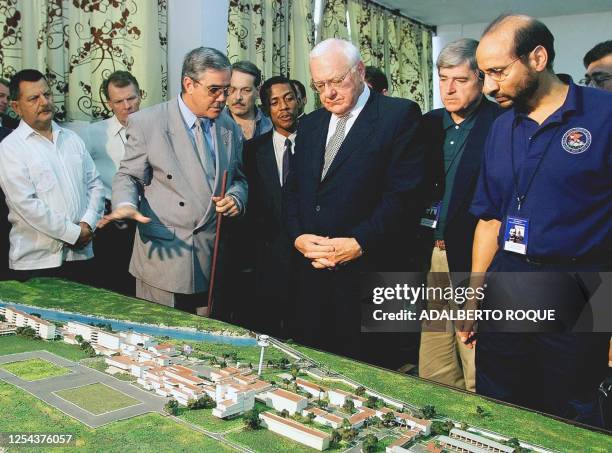 The minister of Public Affairs in Cuba, Carlos Dotres explains a model of the Latin American School of Medicine to George Ryan, Governor of the state...