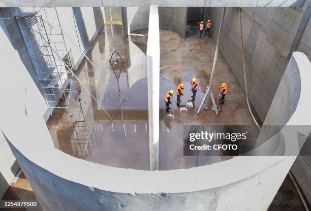 Workers work at the construction site of an industrial sewage treatment plant and water recycling project at a zero-carbon industrial park in Ordos,...