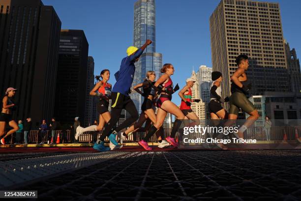 Marathon runners head down Columbus Drive in the early sunlight as the Bank of America Chicago Marathon starts on Oct. 9, 2022.