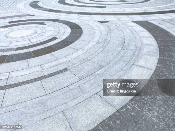 a circular pattern of floor tiles of different colors arranged on the square - concrete footpath stock pictures, royalty-free photos & images